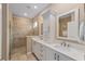 Bright bathroom featuring double sink vanity with white cabinets and tiled walk-in shower at 9839 Sw 99Th Loop, Ocala, FL 34481