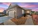 Charming exterior view of home featuring a two-car garage, stone accents, and manicured landscaping at dusk at 9839 Sw 99Th Loop, Ocala, FL 34481