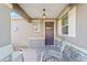 Inviting front porch with stone accents, hanging light fixture, and seating area at 9839 Sw 99Th Loop, Ocala, FL 34481