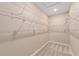 Bright walk-in closet with neutral walls and carpet and metal shelving all around at 9839 Sw 99Th Loop, Ocala, FL 34481