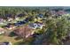 An aerial view of houses in a residential neighborhood with mature trees, featuring a home with a gray roof at 11569 Sw 71St Cir, Ocala, FL 34476