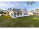 View of the home's back exterior and well-kept yard with enclosed sunroom at 11569 Sw 71St Cir, Ocala, FL 34476