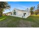 Charming backyard view with lush green grass and a white stucco home featuring a sunroom at 11569 Sw 71St Cir, Ocala, FL 34476