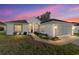 Charming single-story home featuring manicured lawn and a two-car garage, set against a vibrant twilight sky at 11569 Sw 71St Cir, Ocala, FL 34476