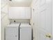 Bright laundry room features a washer, a dryer and white overhead cabinets for easy and convenient storage solutions at 11569 Sw 71St Cir, Ocala, FL 34476