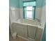 White bathtub with turquoise curtained window at 11663 Sw 72Nd Cir, Ocala, FL 34476