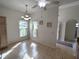 Sunlit dining area featuring tiled floors, chandelier, and windows with floral curtains at 11663 Sw 72Nd Cir, Ocala, FL 34476