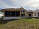 Exterior view of home with screened-in porch, open patio, and lush green lawn at 11663 Sw 72Nd Cir, Ocala, FL 34476