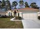 Charming single-story home with manicured lawn and a two-car garage with a brown roof at 11663 Sw 72Nd Cir, Ocala, FL 34476