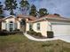 Charming single-story home with manicured lawn and a two-car garage with a brown roof at 11663 Sw 72Nd Cir, Ocala, FL 34476