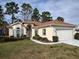 Charming single-story home with manicured lawn and a two-car garage with a brown roof at 11663 Sw 72Nd Cir, Ocala, FL 34476