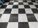 Garage floor tiled in a black and gray checkered pattern, providing a clean and stylish look to the space at 11663 Sw 72Nd Cir, Ocala, FL 34476