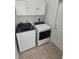 Functional laundry room featuring washer, dryer, and overhead storage cabinets at 11663 Sw 72Nd Cir, Ocala, FL 34476