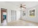 Well-lit bedroom with neutral paint, tile floors, ceiling fan, and closet at 1225 Se 16Th St, Ocala, FL 34471