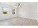 Bright bedroom with neutral paint, tile floors, and two windows at 1225 Se 16Th St, Ocala, FL 34471