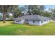 Rear exterior view of a single-story house with mature trees and a well-maintained lawn at 1225 Se 16Th St, Ocala, FL 34471