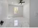 Bright bedroom with a modern ceiling fan, sleek marble floors, and natural light streaming through the window at 12882 Se 42Nd Ct, Belleview, FL 34420