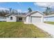 Charming single-story home boasts a manicured lawn, attached garage, and modern architectural design at 12882 Se 42Nd Ct, Belleview, FL 34420