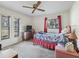 Bedroom with carpet, ceiling fan, two windows, and full bed with pink accents at 16211 Se 62Nd Pl, Ocklawaha, FL 32179