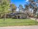 Inviting home with stone accents, lush lawn, and mature trees creating a picturesque setting with inviting curb appeal at 16211 Se 62Nd Pl, Ocklawaha, FL 32179