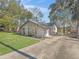 Charming home featuring a stone facade, well-maintained landscaping, and a spacious driveway leading to a two-car garage at 16211 Se 62Nd Pl, Ocklawaha, FL 32179