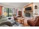 Cozy living room featuring a stone fireplace, large window with natural light, and comfortable seating at 16211 Se 62Nd Pl, Ocklawaha, FL 32179