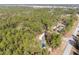 An aerial view of a home in a lush, wooded area showcases the winding driveway and natural surroundings at 18301 Sw 69Th Loop, Dunnellon, FL 34432