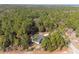 An aerial view of home nestled in a densely wooded area with a long driveway at 18301 Sw 69Th Loop, Dunnellon, FL 34432