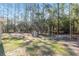 Large backyard with play set, fire pit, mature trees, and wooded backdrop at 18301 Sw 69Th Loop, Dunnellon, FL 34432