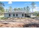 Rear exterior view of the home featuring a covered patio and spacious backyard at 18301 Sw 69Th Loop, Dunnellon, FL 34432