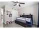 Bright bedroom with a ceiling fan, a window with blue curtains, and gray wood-look floors at 18301 Sw 69Th Loop, Dunnellon, FL 34432