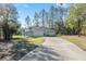 Side view of a modern home featuring a long driveway, attached garage, and a basketball hoop at 18301 Sw 69Th Loop, Dunnellon, FL 34432