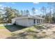 Side view of the home showcasing the spacious backyard, patio and driveway at 18301 Sw 69Th Loop, Dunnellon, FL 34432