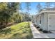 Exterior side view of a home showcasing a pathway, manicured landscaping, and a two-car garage at 18301 Sw 69Th Loop, Dunnellon, FL 34432