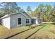 Exterior side view of a single-story home with lush green grass and mature trees at 18301 Sw 69Th Loop, Dunnellon, FL 34432