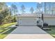 Attached two-car garage featuring a concrete driveway, basketball hoop, and well-maintained landscaping at 18301 Sw 69Th Loop, Dunnellon, FL 34432