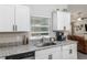 Close-up of the bright kitchen featuring granite countertops, stainless steel appliances, and white cabinetry at 18301 Sw 69Th Loop, Dunnellon, FL 34432