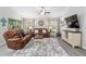 Comfortable living room features leather sofas, a ceiling fan, neutral tones, and wood-look flooring at 18301 Sw 69Th Loop, Dunnellon, FL 34432