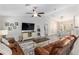 Comfortable living room features leather sofas, a ceiling fan, neutral tones, and wood-look flooring at 18301 Sw 69Th Loop, Dunnellon, FL 34432