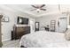 Well-lit main bedroom featuring wood-look floors, a TV, and access to the ensuite bathroom at 18301 Sw 69Th Loop, Dunnellon, FL 34432