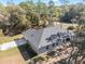 Aerial rear view of home featuring a green lawn, gray shingles and a basketball court at 18301 Sw 69Th Loop, Dunnellon, FL 34432