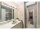 Neutral bathroom featuring a large mirror with Hollywood lights, a sink vanity, and walk-in shower at 1947 Se 37Th Court Cir, Ocala, FL 34471