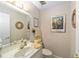 Inviting powder room features artwork, a sink vanity, mirror, and neutral decor at 1947 Se 37Th Court Cir, Ocala, FL 34471