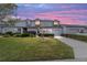 Charming townhome at dusk, featuring a well-manicured lawn and private driveways leading to garages at 1947 Se 37Th Court Cir, Ocala, FL 34471