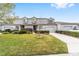 Charming townhouse exterior featuring well-manicured lawn, shrubs, dormer windows, and attached garages at 1947 Se 37Th Court Cir, Ocala, FL 34471