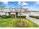 Exterior view of a well-maintained townhouse with green lawn, mature landscaping, and a driveway at 1947 Se 37Th Court Cir, Ocala, FL 34471