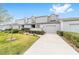 Inviting townhome featuring a well-maintained lawn and a paved driveway leading to the garage at 1947 Se 37Th Court Cir, Ocala, FL 34471