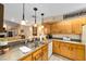 Well-lit kitchen with wood cabinets, stainless steel sink, breakfast bar, and an open view to living area at 1947 Se 37Th Court Cir, Ocala, FL 34471