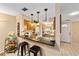 Stylish kitchen bar featuring granite countertops, pendant lighting, and views into the kitchen and entry door at 1947 Se 37Th Court Cir, Ocala, FL 34471