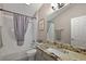 Bathroom with granite countertops, a shower-tub, and a decorative shower curtain at 1986 Altamonte Way, The Villages, FL 32162